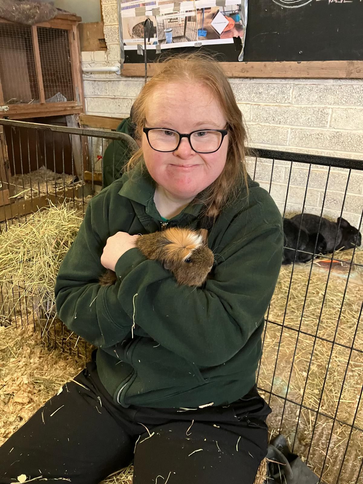 A participant holding a guinea pig during an animal care activity